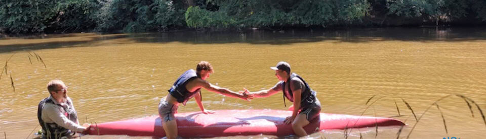 Zwei Schüler sitzen auf einem Kanu