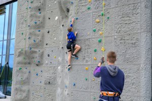 Mädchen klettert auf Klassenfahrt an der Kletterwand